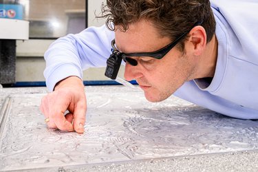 Graveren van de mal voor de nieuwe goudleervellen.