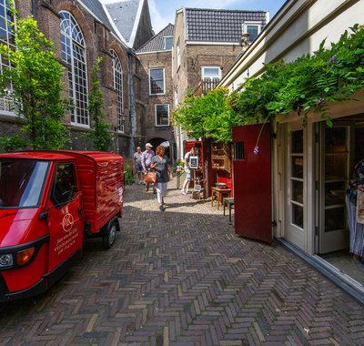Small street in Dordrecht with a parked red van.