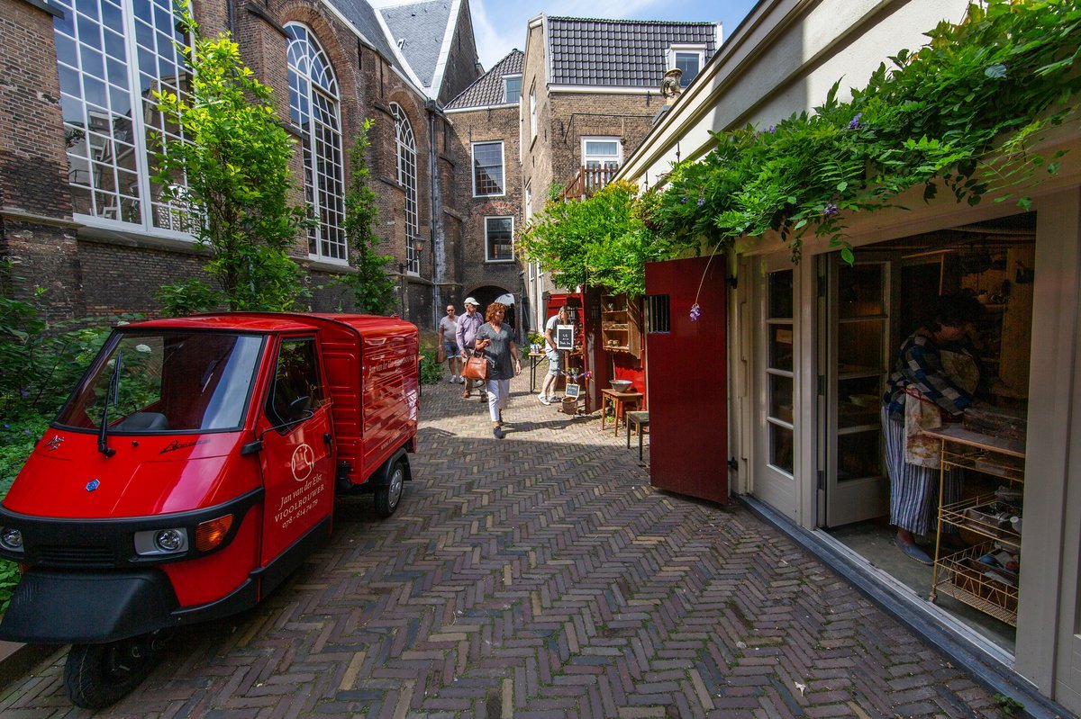 Small street in Dordrecht with a parked red van.