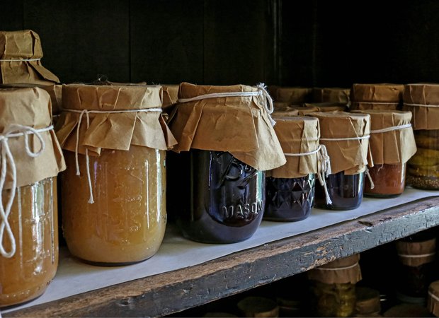 Ingemaakte groenten en fruit in potten op een plank