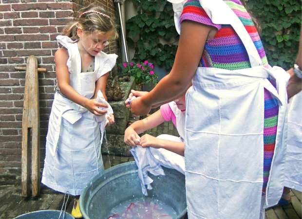 Meisjes doen de was in een tobbe Meisjes doen de was in een tobbe