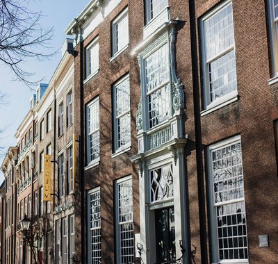 Huis van Gijn vanaf de straat. Het is winter, de bomen zijn kaal.